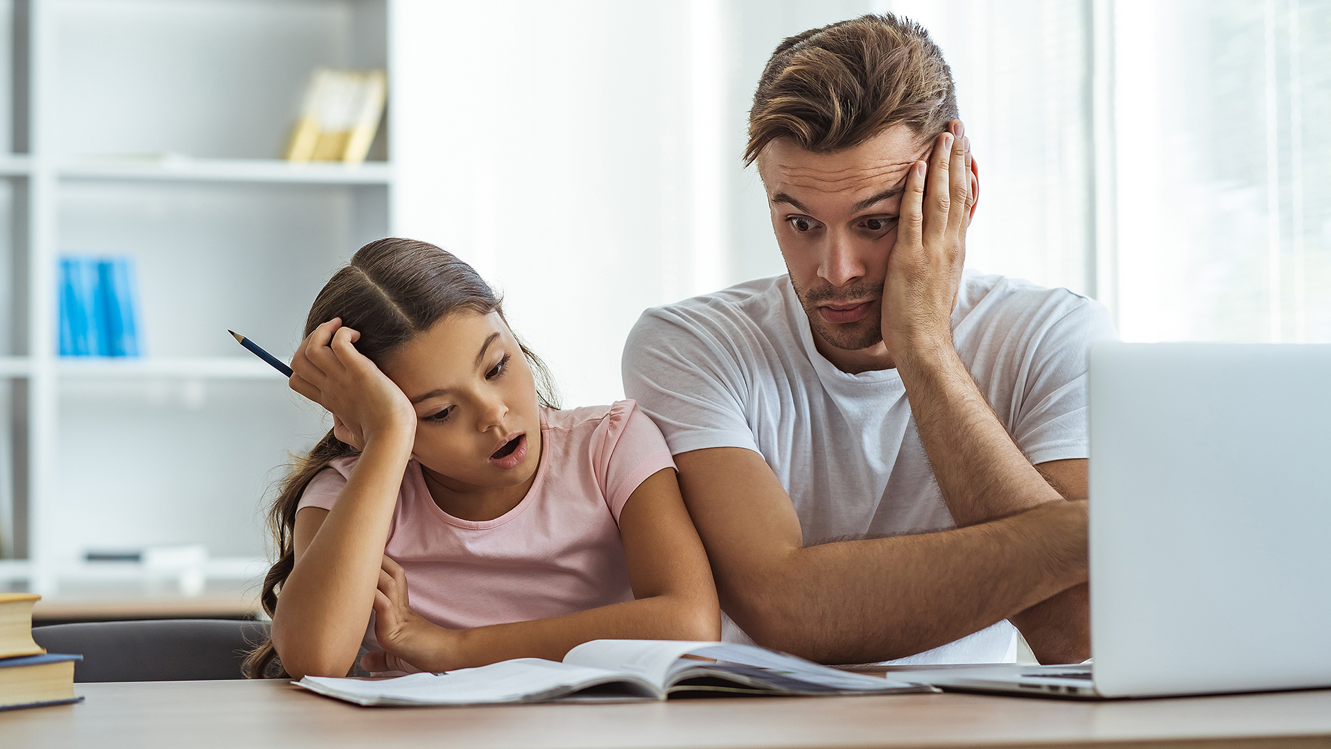 Vater versucht seiner Tochter beim Lernen zu helfen, ist jedoch völlig überfordert. Online Elternberatung kann helfen!
