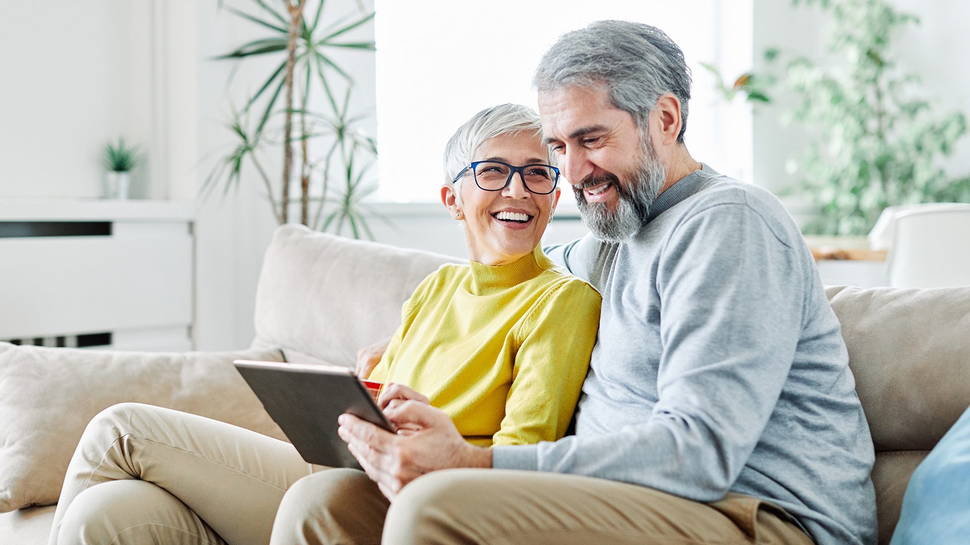Glückliches Senioren Paar nutzt ein Tablet für das Forever Fit Gedächtnistraining